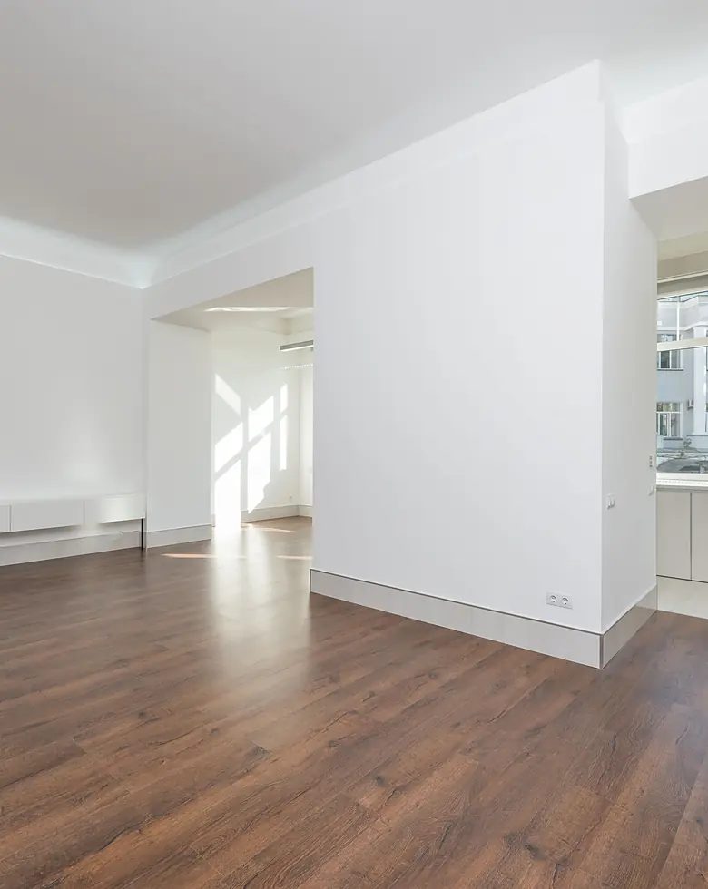 Eine leergeräumte helle Wohnung mit frisch gereinigtem Parkett, bereit zur Übergabe.